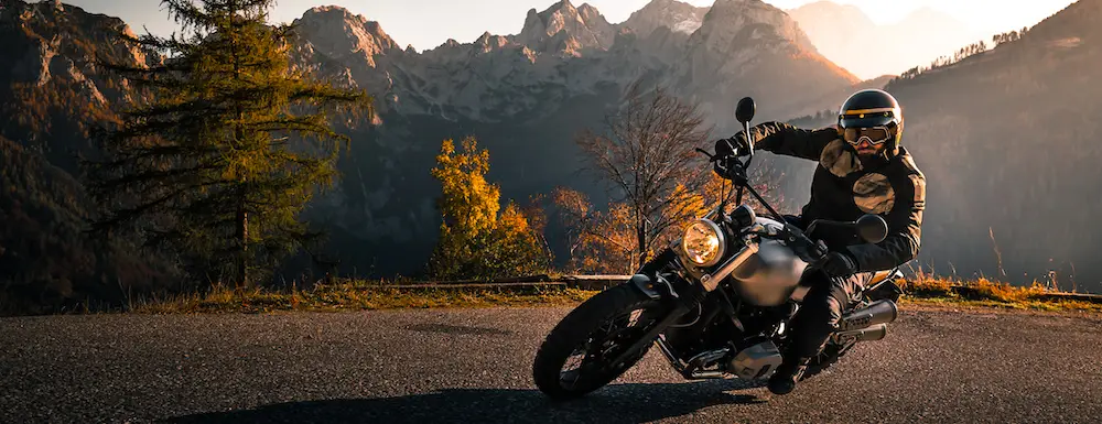 Motorcyclist riding near mountain range