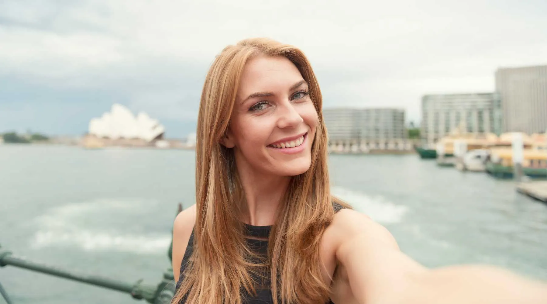 A woman traveling in Sydney taking a selfie