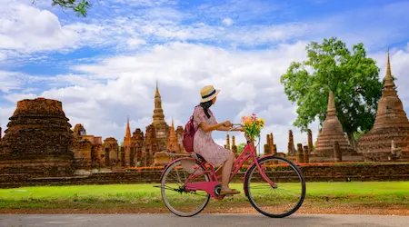 Bicyclist rides past pagodas