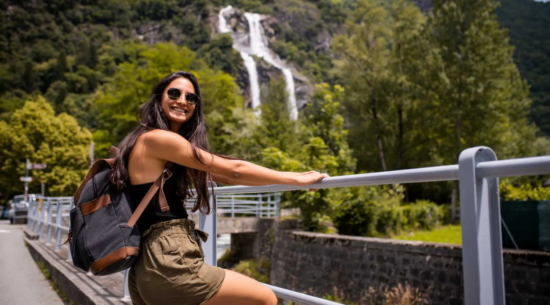 A woman traveling with a waterfall nearby