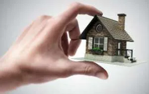 A tiny house in a man's hand. Image: Shutterstock