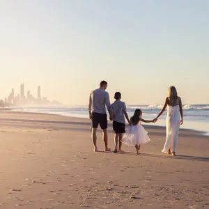 Rear View Of Family Walking On Beach In Gold Coast, Australia