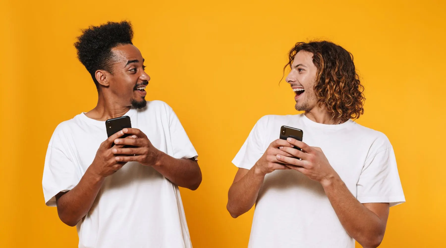 Portrait of a Two Happy Young Men Holding Mobile Phones