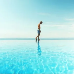 Man walking on the edge of a pool