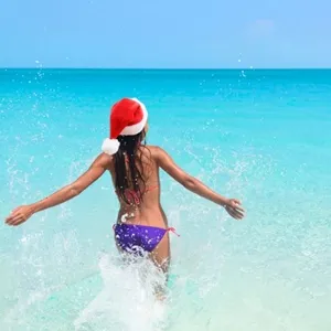 Girl on the beach wearing santa's hat