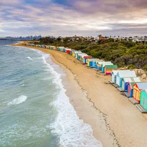 Drone view of Brighton Bathing Boxes in Victoria with cloudy sky in the background, Australia