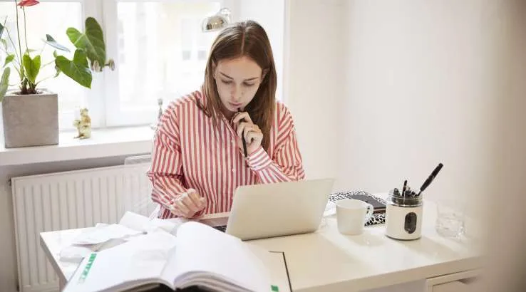 Woman sitting in home office working on laptop. Image: Getty Images