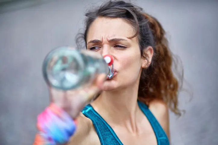 Woman drinking water on a run