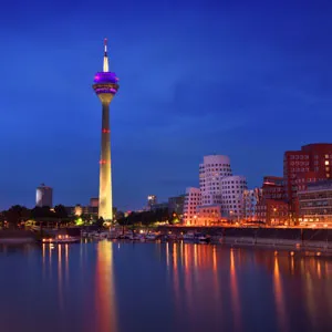 View of Düsseldorf during the blue hour at the Rhine river with the Rheinturm Tower and the media harbor.