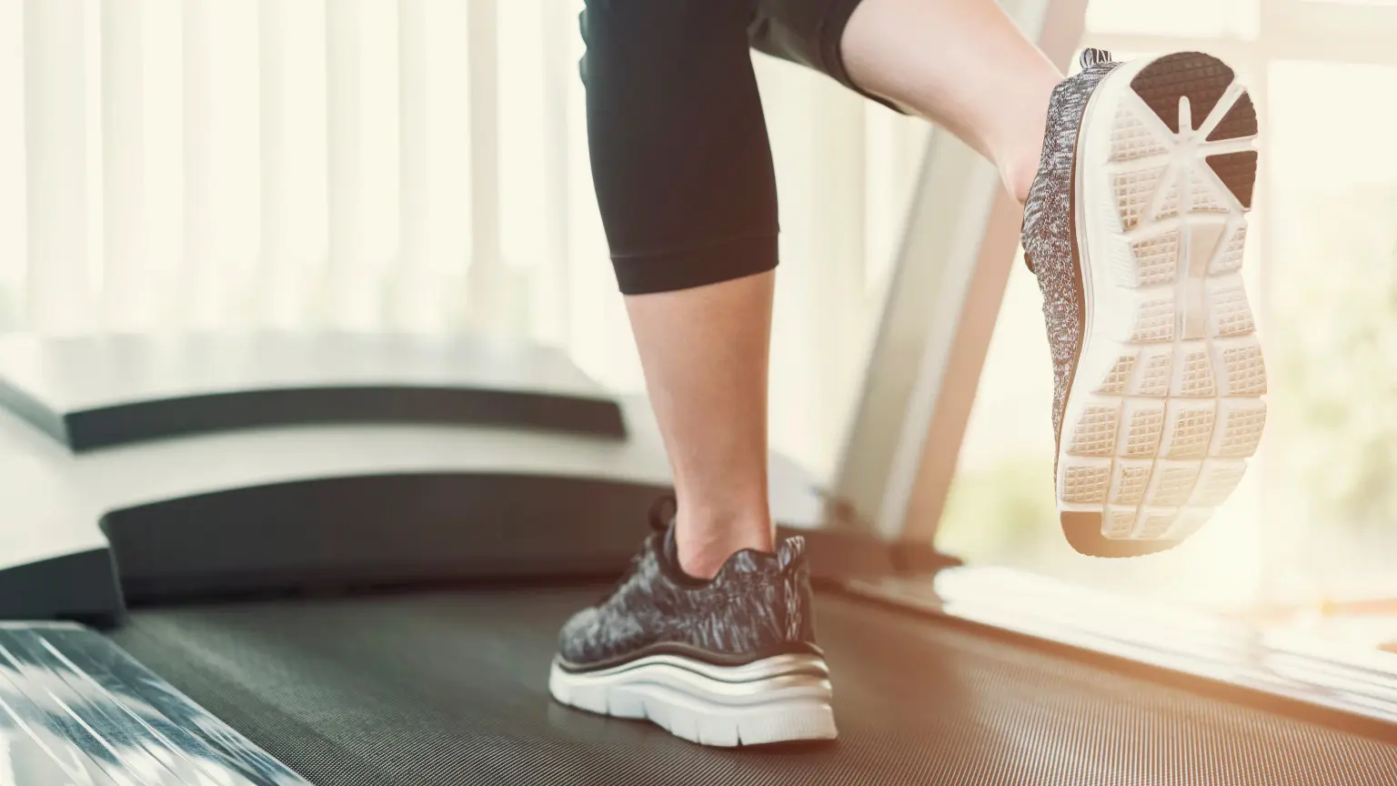 Low Section Of Woman Running On Treadmill