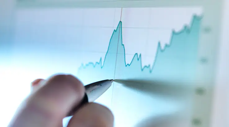 Hand of a stock broker analysing line graph on computer screen