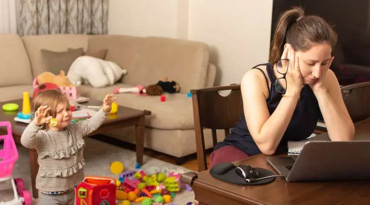 Stressed woman working while being interrupted by child
