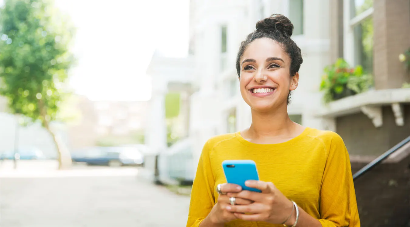 Happy_woman_holding_phone_gettyimages1350x750