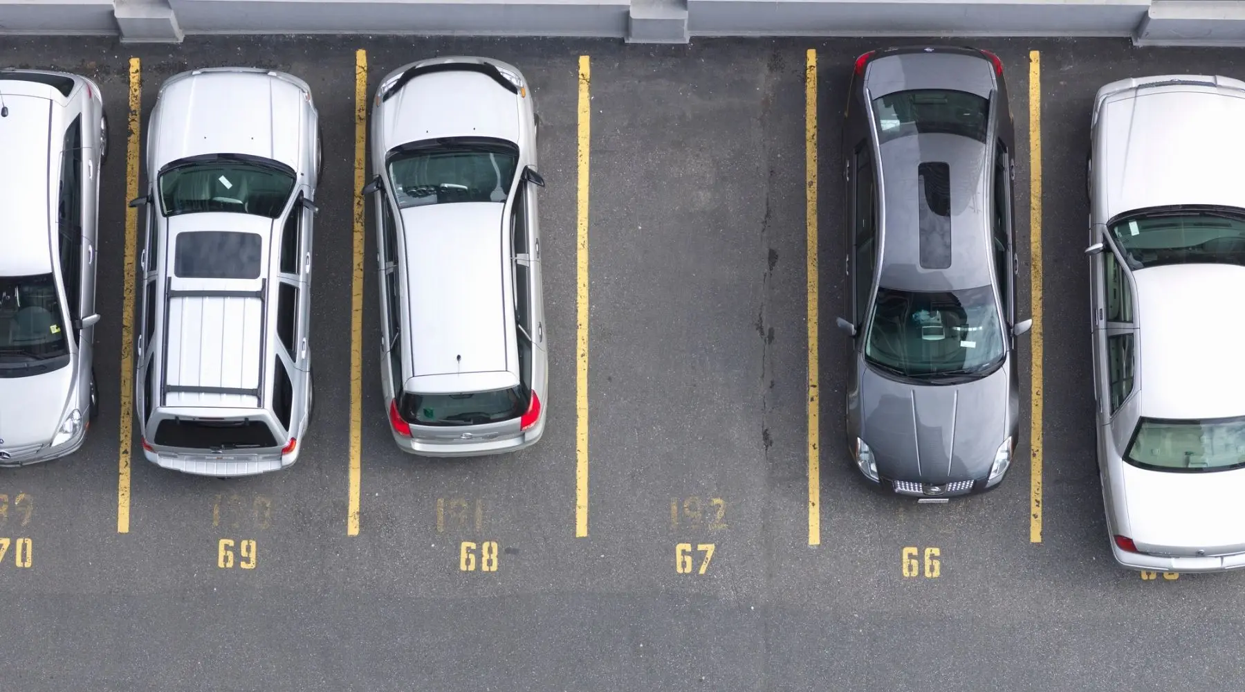 Cars are parked in a line, with one space remaining. 