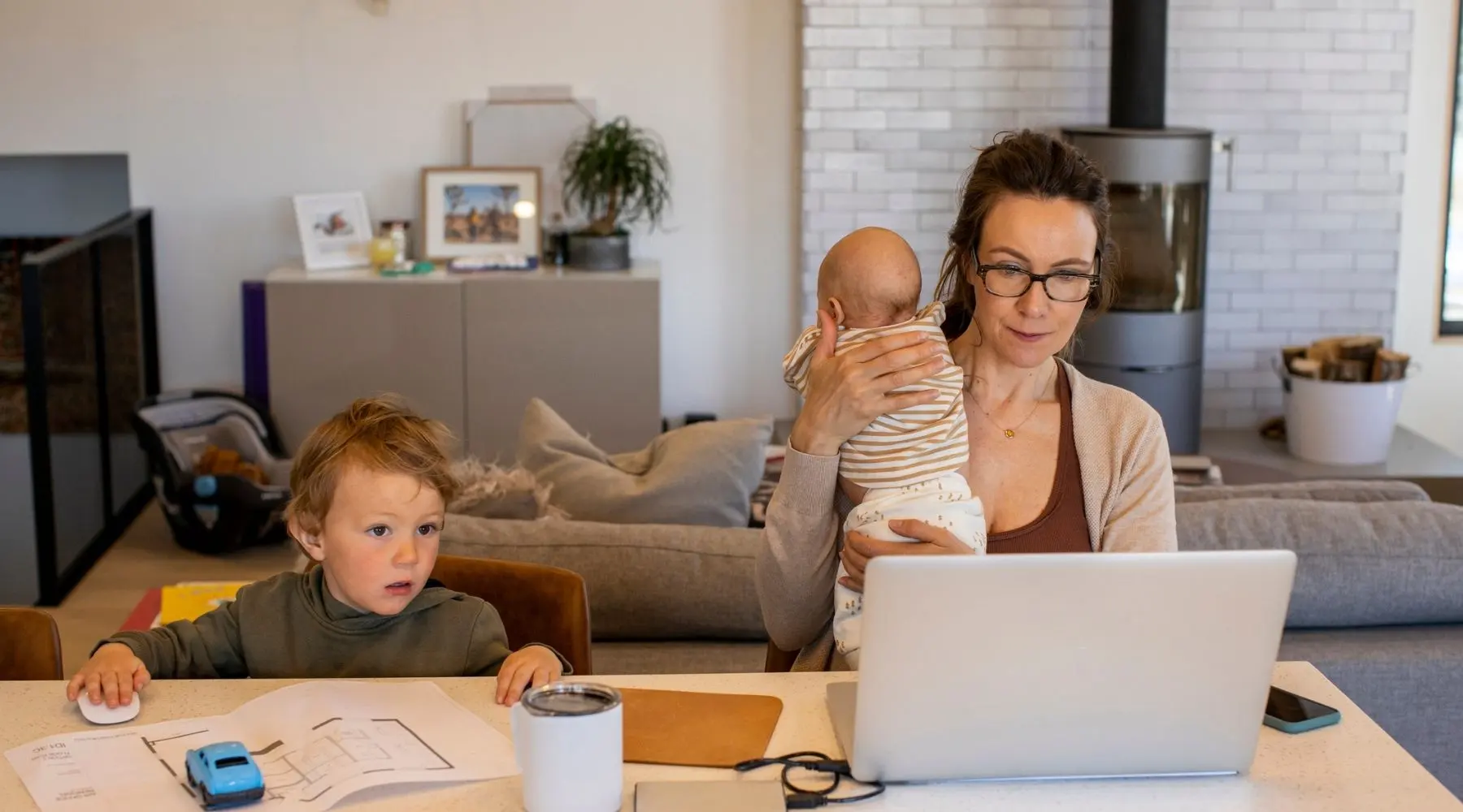 A woman works from home alongside her two young children.