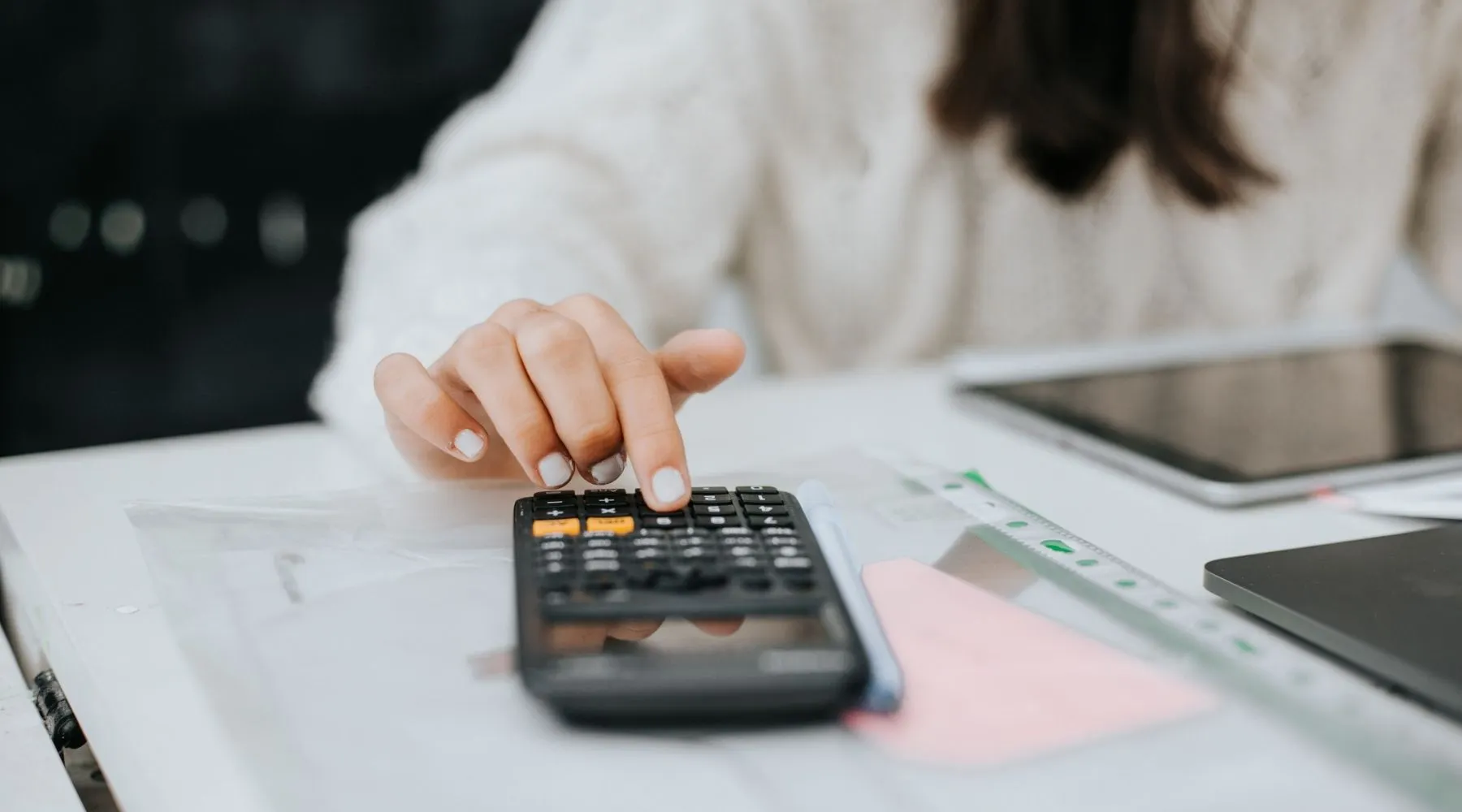 A young woman uses a calculator.