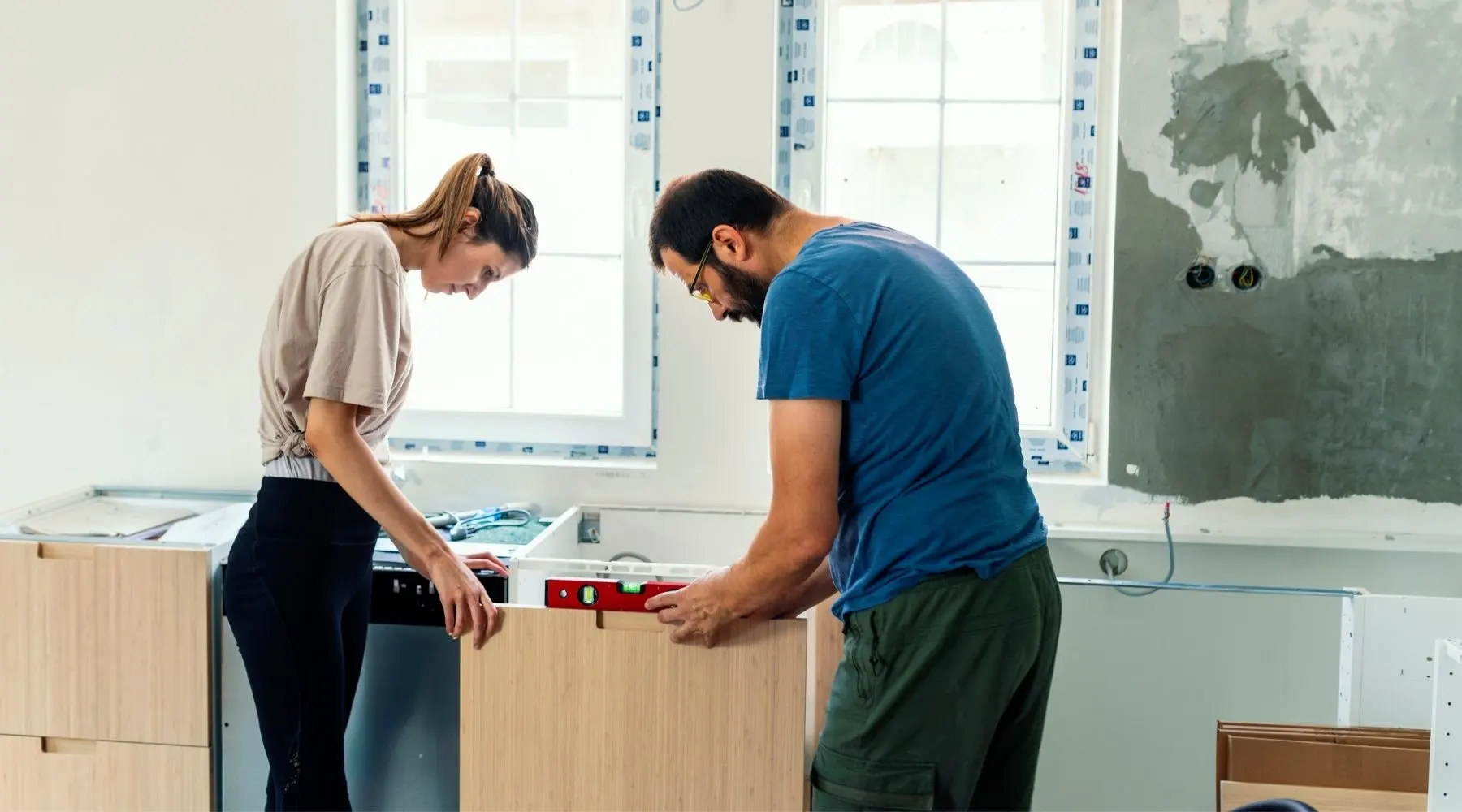 Father and his daughter with hearing aid installing furniture together.