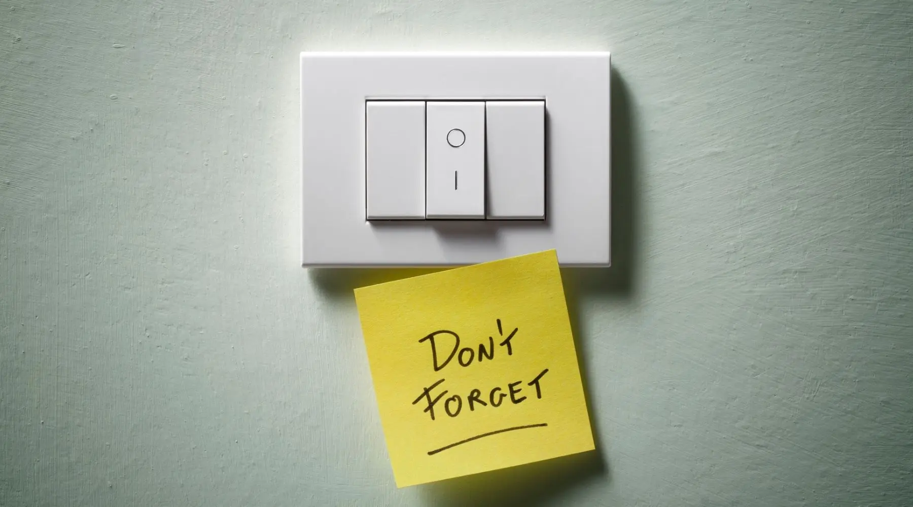 Light switch with yellow sticky note which reads 'don't forget'