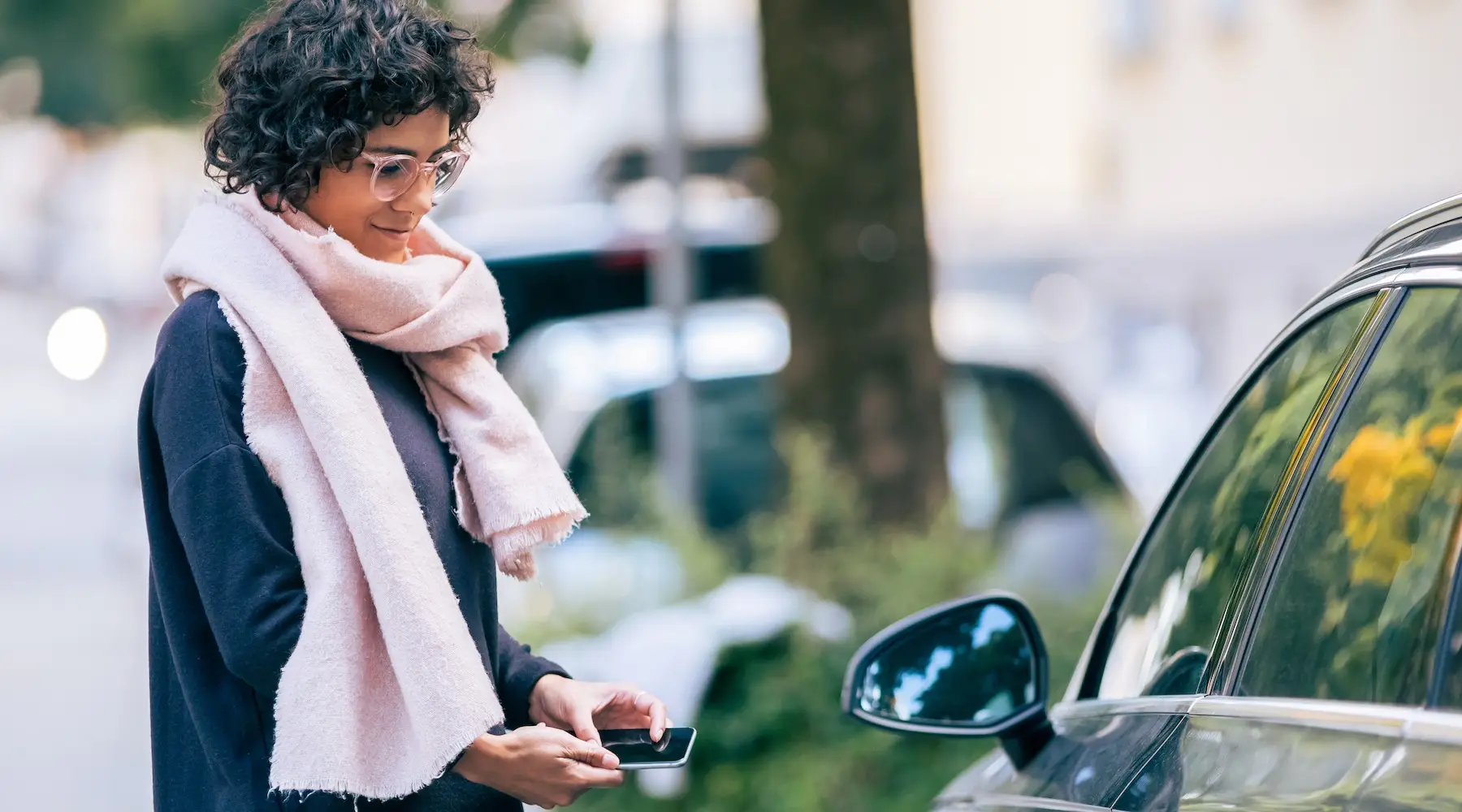 woman with phone near a car