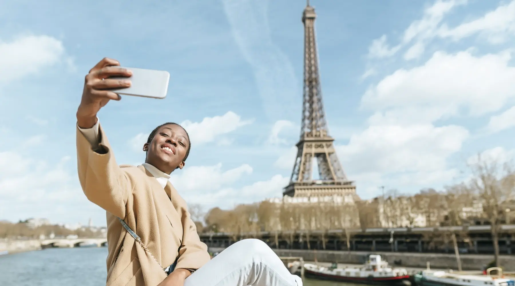 Woman taking selfie in front of the Eiffel Tower