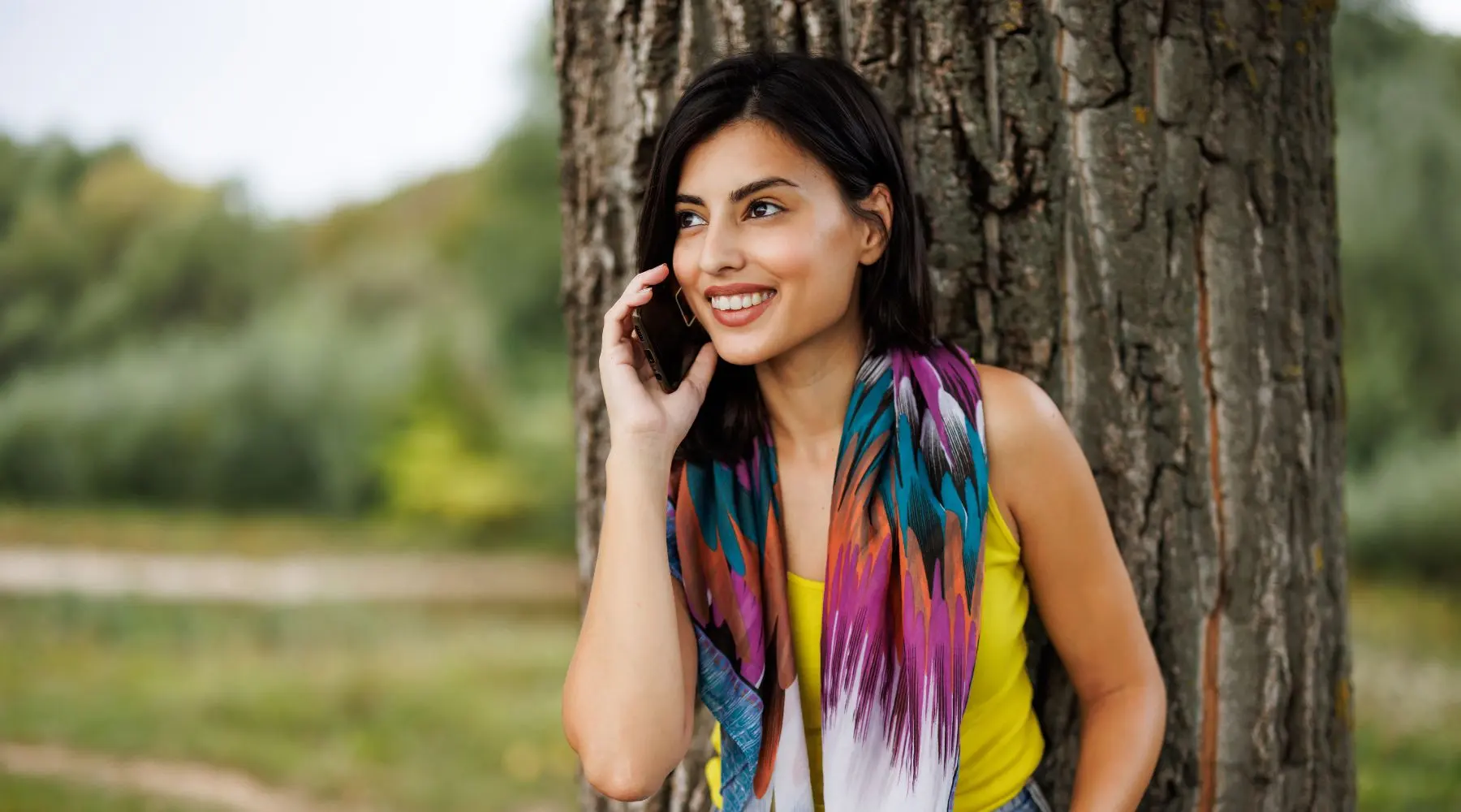 Woman on phone near a tree