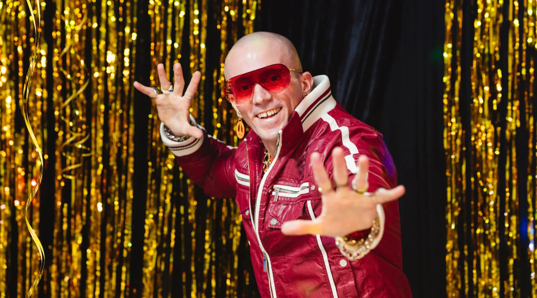 Bald man wearing red jacket and sunglasses