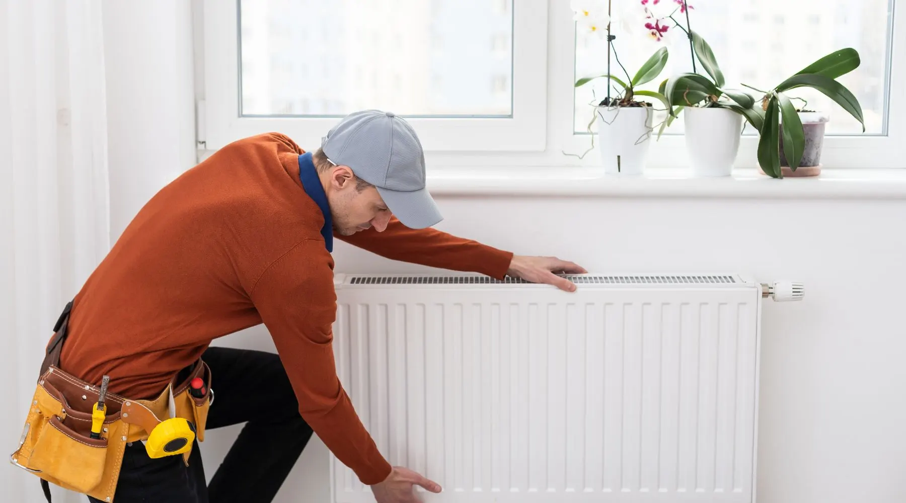 Man fixing heater_Canva_1800x1000